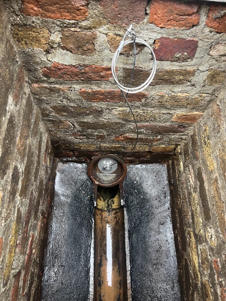 Rat flap installed on a drainpipe to prevent rodent entry into a home.